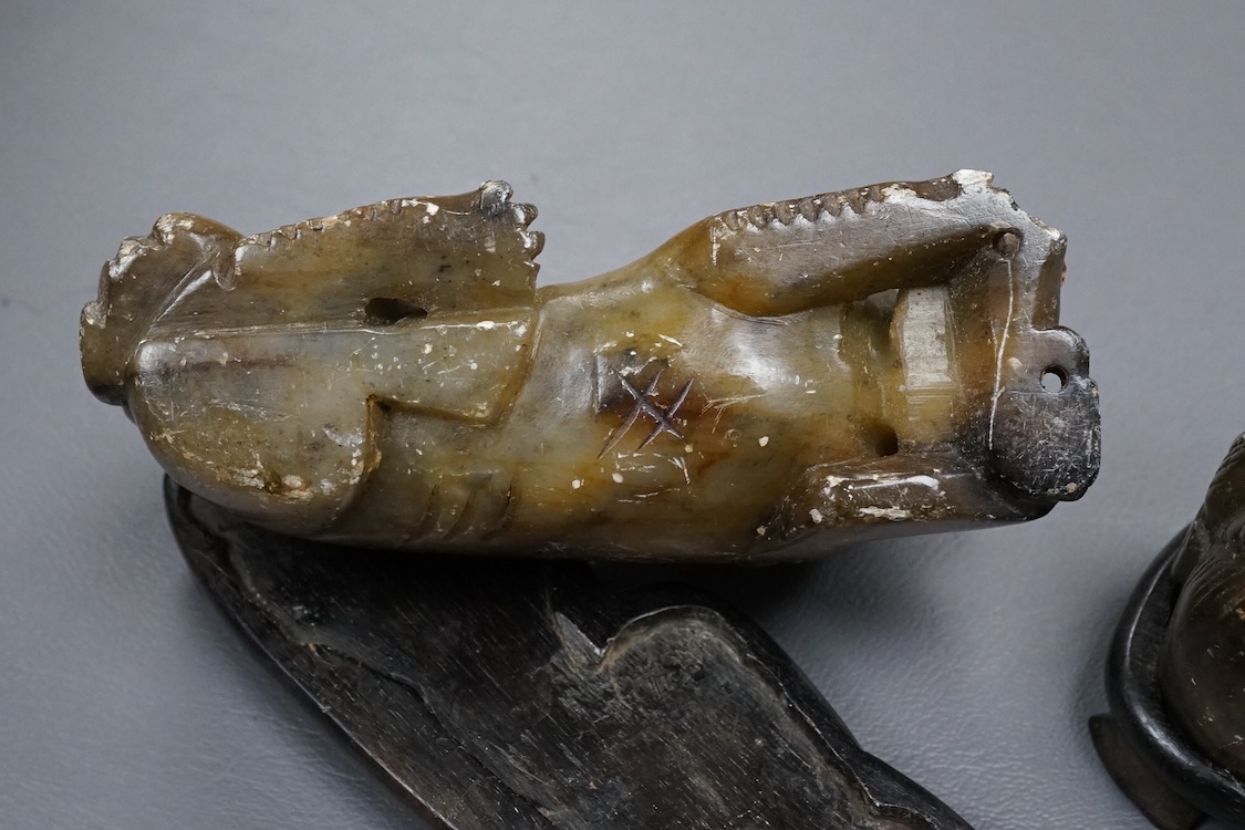 A pair of Chinese soapstone figures of lion dogs, on wood stands, 11cm wide